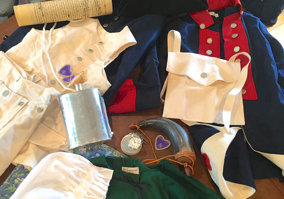 Reproduction Items from the 18th century including a canteen, clothes, and military medals.
