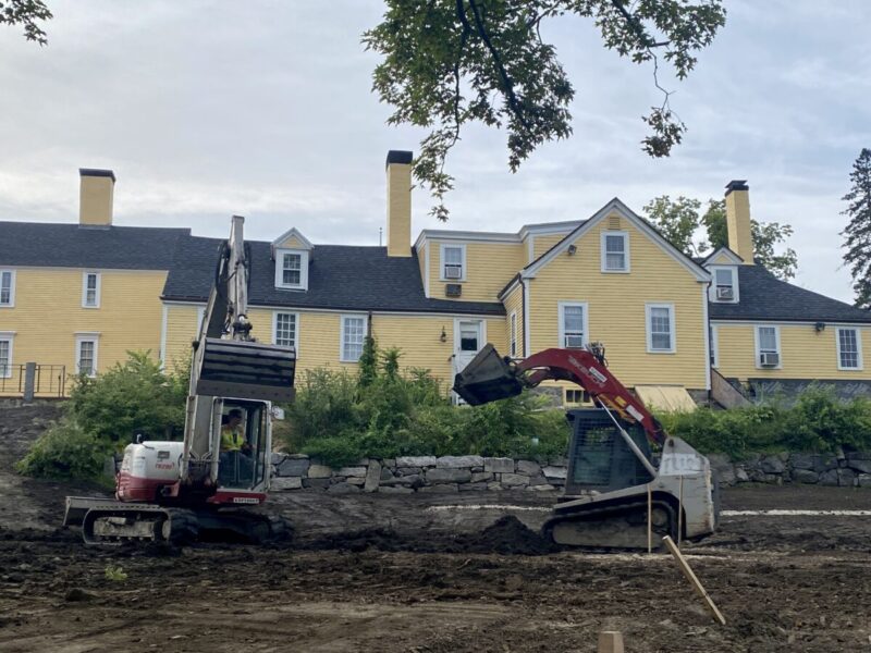 Two construction vehicles working to level the lawn off the Independence Museum