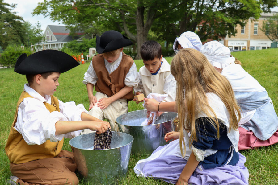 Children in 18th century clothing washing clothes