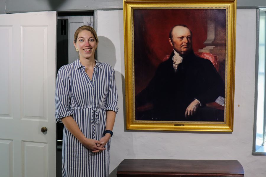 Museum Directo Emma Stratton in front og a large oil portrait of John Taylro Gilman