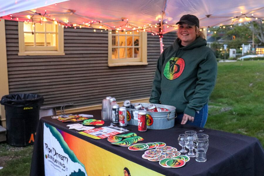 Brewer from Pipe Dream Brewery in Londonderry standing behind a table full of their beers and merchandise.