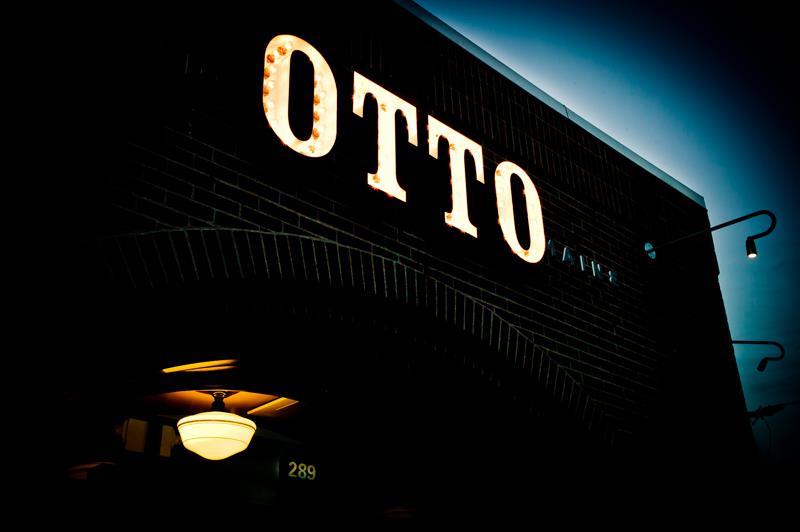 darkened restaurant exterior with lit sign that reads OTTO